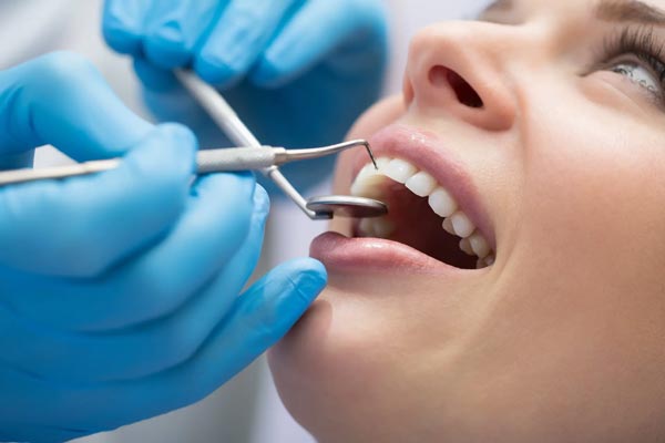 a woman at dentist for painless teeth whitening