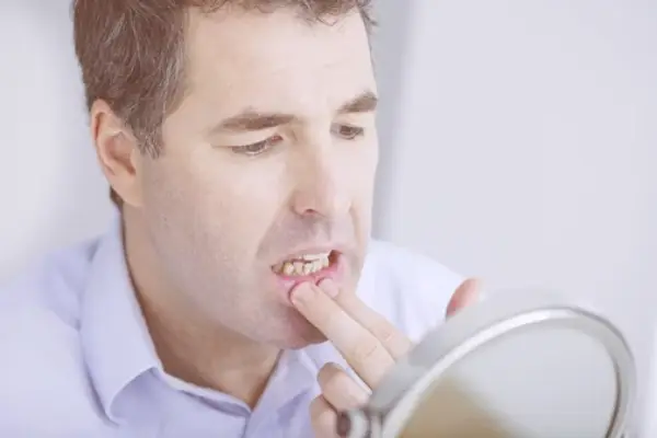 a man watching his teeth on mirror