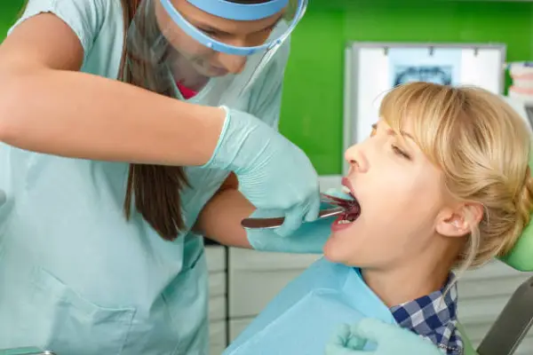 a dentist and A lady at the dentist for tooth extraction